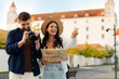 © Home-stock - Tourists couple enjoying their time outside walking and looking at landmarks, woman holding map while man taking photos