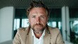 © svastix - A close-up portrait of a confident, bearded businessman in a modern workspace, showcasing determination and professionalism with thoughtful expression and impressive features.