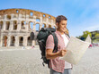 © Ljupco Smokovski - Smiling male tourist looks at a map in front of the Colosseum
