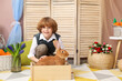 © New Africa - Little boy with cute Easter bunny in wooden crate indoors
