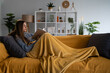© Zoran Jesic - Woman relaxing at home reading book on sofa