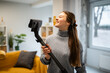 © Zoran Jesic - Young woman enjoying cleaning her home with vacuum cleaner