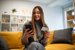 © Zoran Jesic - Woman online shopping using smartphone and credit card at home