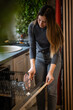 © Zoran Jesic - Woman loading dirty dishes into kitchen dishwasher