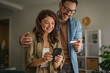 © Miljan Živković - Happy couple enjoying online shopping using phone and credit card