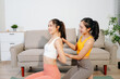 © Nuttapong punna - Personal trainer assisting woman with yoga workout at home. Indoor fitness training, stretching and wellness lifestyle with online guidance and healthy routine.