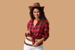 © Pixel-Shot - Beautiful African-American cowgirl on beige background