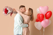 © Pixel-Shot - Lovely couple with bouquet of flowers and heart-shaped balloons on beige background. Valentine's Day celebration