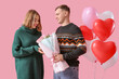 © Pixel-Shot - Lovely couple with bouquet of flowers and heart-shaped balloons on pink background. Valentine's Day celebration