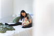 © NZstockphoto - Asian mum reading a book to toddler daughter in bed