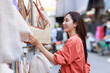 © Phimwilai - Young woman enjoying market shopping selecting handcrafted bags