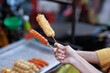 © Phimwilai - Hand holding fried street food snack on stick