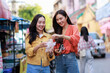 © Phimwilai - Asian friends enjoying street food during city exploration