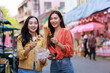 © Phimwilai - Young asian women enjoying street food during market travel