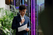 © Westend61 - Businessman analyzing document in modern office with plants and technology