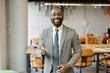 © Westend61 - Confident businessman smiling in modern office workspace