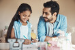 © peopleimages.com - Homework, father and girl with drawing, notebook or learning for education assessment. Creative child, dad and development with student, art talent and motor skills lesson for hobby knowledge in home