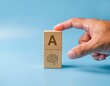 © Eamin - Hand stacks wooden blocks showing letter a and brain symbol