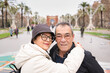 © Fotografia Juan Reig - Senior couple embracing and smiling during a romantic urban stroll in barcelona, enjoying travel, sightseeing and warm moments together in front of the arc de triomf