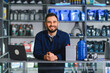 © Serhii - Smiling auto parts store salesman working at desk
