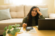 © AntonioDiaz - Stressed young woman dealing with financial problems at home, calculating bills and having money anxiety
