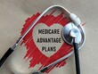 © AhmadYani - Red heart shape shadow and medicare advantage plans writing and stethoscope, healthcare, insurance and medical plan concept