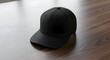 © Fizzah - A simple black baseball cap rests on a wooden surface showcasing its minimalist design and everyday appeal for casual fashion and outdoor activities