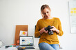 © baranq - Female photographer reviewing camera in creative office