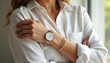 © miss irine - Woman wears white shirt with watch and bracelets. Closeup on female hand showing gold jewelry and timepiece. Elegant lady shows accessory collection with simple design.