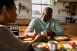© Marko Geber - Mature couple talking over coffee in home kitchen
