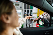 © Jelena - Woman making credit card payment at gas station pump