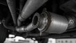 © miss irine - Close-up of car catalytic converter and exhaust pipes. Metal auto part shows signs of wear and rust. Underside view of automobile emission system.