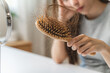 © Pormezz - Close-up young woman brushing her hair and have many hair loss on the comb