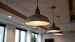 © Bussakon - Modern gray pendant light fixtures hanging from a contemporary office ceiling providing ambient illumination
