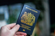 © nicholasjermy - British passport held in hand in a modern lifestyle setting, representing travel, identity, and international mobility