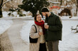 © BGStock72 - Couple laughing together in a snowy park holding warm drinks