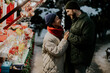 © BGStock72 - Couple enjoys holiday market at night in winter setting with festive decorations