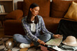 © Home-stock - Sad traveler woman looking at map while packing suitcase, sitting on the floor in living room, preparing for vacation