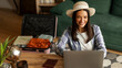 © Home-stock - Happy woman tourist using laptop at home, packing suitcase, booking hotel or flight tickets online, planning trip, panorama with copy space
