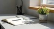 © Mahfujur Rahman Mila - A serene workspace with a laptop, notebook, and potted plant by the window