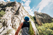 © Soloviova Liudmyla - Back view of male rock climber with blue helmet and green rope looking at massive cliff wall. Professional mountaineer preparing for extreme sports adventure in mountains. Extreme adventure sport.