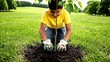 © fotogurme - Young boy planting a tree sapling in a sunny park, hands in fresh soil and gardening gloves, outdoor education and ecology theme, Earth Day conservation
