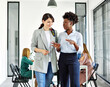 © Lumos sp - Portrait of two young business woman having a meeting or presentation and seminar standing in the office. Portrait of a young business woman talking