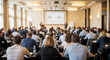 © Sianna - Business meeting held in a large conference room with many attendees listening to speakers in front of a presentation screen
