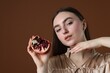 © New Africa - Beautiful woman with ripe pomegranate on brown background. Space for text