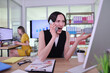 © H_Ko - In a bright office space, a woman displays visible frustration while talking on her phone.