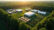 © Viktor - Aerial view of modern farm with greenhouses crops and biogas plant. Agricultural tech facility works in natural forest setting. Sustainable food production at dawn.