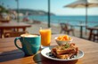 © Viktor - Couple enjoys breakfast at seaside cafe. Coffee latte, orange juice, french toast served at table. Ocean backdrop, sunny day, vacation vibes, relaxation.