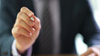 © H_Ko - A confident businessman is ready to sign crucial papers with a sleek pen in a contemporary office, illuminated by soft afternoon light filtering through large windows.