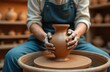 © Maryna - Ceramist shapes clay vase on pottery wheel. Hands mold earthen vessel on spinning disc. Artist creates ceramic art in workshop. Traditional craft, handmade pottery.